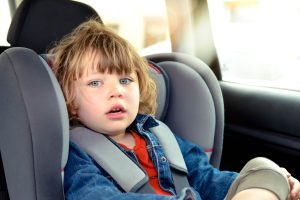 child car seat in backseat of vehicle representing Michigan OWI with minor passenger charge for healthcare professionals